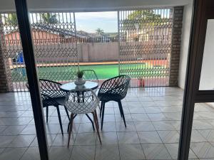 a table and chairs on a patio with a view of a pool at Flamingo B&B in Richards Bay