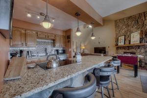 a kitchen with a counter and some chairs in it at Top Floor 2 Bedroom Ski-In & Walk to Main St in Breckenridge