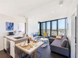 a kitchen and living room with a couch and a table at Story Bridge and City View Skyhigh Luxe 2 bed Unit in Brisbane