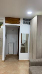 ein Wohnzimmer mit einem Sofa und einem Spiegel in der Unterkunft La finestra sul parco in Villetta Barrea