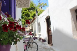 una bicicleta estacionada junto a un edificio blanco con flores en Amaranda Ada Evi, en Bozcaada