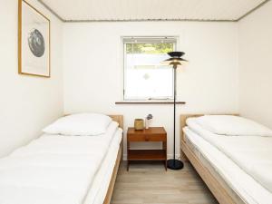 - 2 lits dans une chambre avec une table et une fenêtre dans l'établissement Holiday home Læsø, à Læsø
