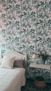 1 dormitorio con 1 cama y papel pintado con motivos florales en Casa Bienvenida, en Bienvenida