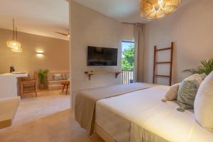 Aparthotel Onda Maya - Adults Only في جزيرة هول بوكس: غرفة نوم مع سرير وغرفة معيشة