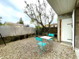 eine Terrasse mit 2 Stühlen, einem Tisch und einem Zaun in der Unterkunft Grand Studio Chez Soi - Queen size bed - Terrasse in Oyonnax