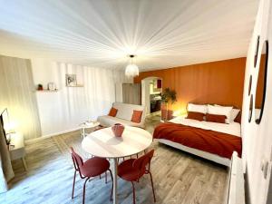 1 dormitorio con 1 cama, mesa y sillas en Grand Studio Chez Soi - Queen size bed - Terrasse, en Oyonnax
