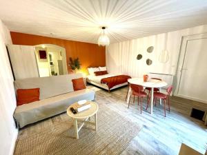 sala de estar con sofá y mesa en Grand Studio Chez Soi - Queen size bed - Terrasse, en Oyonnax
