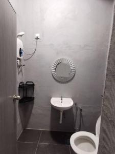ein Badezimmer mit einem WC, einem Waschbecken und einem Spiegel in der Unterkunft Ipoh town centre glamping home 13pax in Ipoh