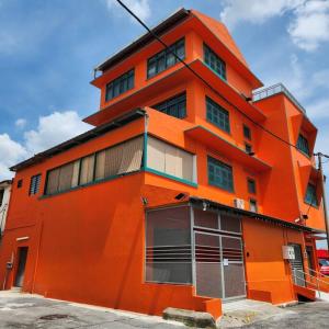 un edificio naranja con muchas ventanas en Ipoh town centre glamping home 13pax, en Ipoh