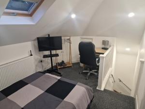 a bedroom with a bed and a desk and a television at Confystay in London
