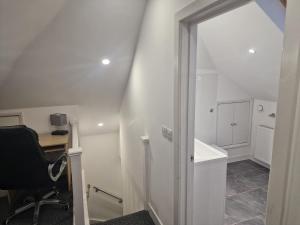 an attic room with a desk and a chair at Confystay in London