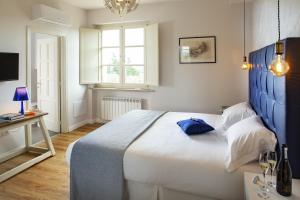 une chambre avec un grand lit et une tête de lit bleue dans l'établissement CorteViva Boutique B&B, à Pérouse