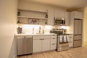 a kitchen with white cabinets and stainless steel appliances at Urban Oasis in Overton Square in Memphis