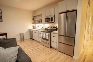 a kitchen with a stainless steel refrigerator and white cabinets at Urban Oasis in Overton Square in Memphis