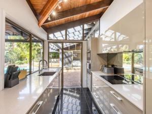 an open kitchen with stainless steel countertops and glass windows at Hidden Bali style 5BR house in Robertson in Brisbane