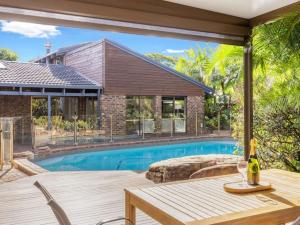 an outdoor patio with a table and a swimming pool at Hidden Bali style 5BR house in Robertson in Brisbane