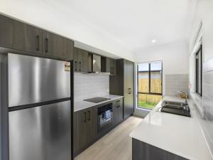 a kitchen with a stainless steel refrigerator and a window at Well decorated cozy 3BR home at Browns Plain in Browns Plains