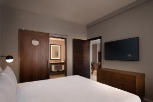 a bedroom with a white bed and a flat screen tv at Four Points by Sheraton  in Punta Cana