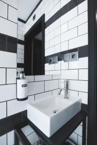 een badkamer met een witte wastafel en een spiegel bij Alma Candida 25 