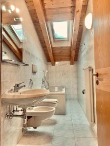 a bathroom with two toilets and a sink and a tub at Cesa Cascata in Canazei