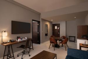 sala de estar con TV, mesa y sillas en Four Points by Sheraton , en Punta Cana