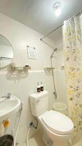 bagno bianco con servizi igienici e lavandino di Castle Place Condo Staycation Marilao a Marilao