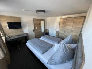 een slaapkamer met 2 bedden en een bureau en een bed sidx sidx sidx bij Gasthof zum Rößle Lautrach in Lautrach
