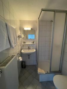 een badkamer met een douche en een wastafel bij Gasthof zum Rößle Lautrach in Lautrach