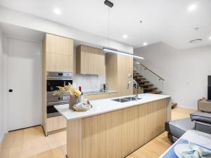 a kitchen with a sink and a stove top oven at Conveniently Located Luxury 4BR Townhouse in Brisbane