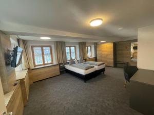 Großes Zimmer mit einem Bett und einem TV. in der Unterkunft Gasthof zum Rößle Lautrach in Lautrach