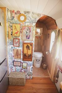 baño con aseo y cuadros en la pared en Purdon Groves Wanderlust Skoolie, 