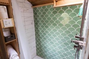 y baño con pared estampada de color verde y blanco. en Purdon Groves Wanderlust Skoolie, 