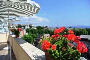イスタンブールにあるフォルス ホテルの傘付きバルコニーの赤い花の鉢