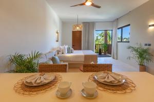 Aparthotel Onda Maya - Adults Only في جزيرة هول بوكس: غرفة نوم بسرير وطاولة عليها صحون