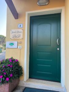 a green front door of a house with flowers at Garda Dream in Lazise