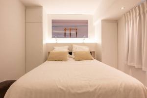 Schlafzimmer mit einem großen weißen Bett und einem Fenster in der Unterkunft Luxe appartement Eliza - frontaal zeezicht in Mariakerke in Ostende
