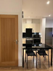 een keuken met een tafel en stoelen en een deur bij studio flat in streatham in Londen