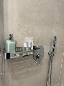 une salle de bains avec un distributeur de savon sur un mur dans l'établissement B&B La Villa Cittanova, à Cittanova
