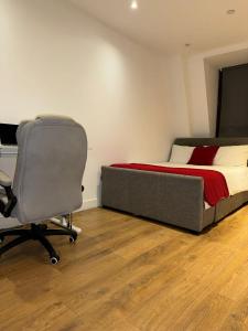 a bedroom with a bed and a desk and a chair at studio flat in streatham in London
