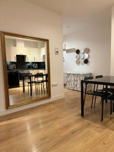 een spiegel in een woonkamer met een tafel en een keuken bij studio flat in streatham in Londen