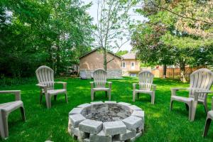 een groep stoelen rond een vuurplaats bij Charming 3BR Bungalow - Hot Tub in Port Hope