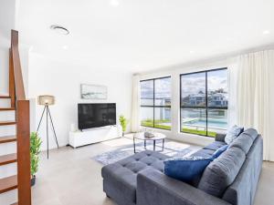 a living room with a couch and a large window at Stunning waterfront family home with pontoon newly in Gold Coast