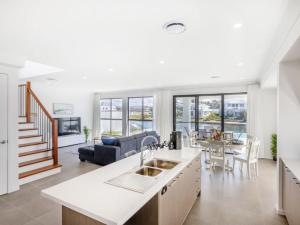 a kitchen and living room with a couch and a table at Stunning waterfront family home with pontoon newly in Gold Coast