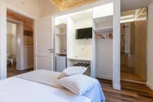 - une chambre avec un lit et une télévision murale dans l'établissement Vittoria Luxury House, à Lecce