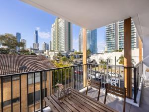 黄金海岸Comfortable 1BR Apt with pool and carpark的阳台设有长凳,享有城市美景。