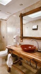 uma casa de banho com um lavatório de madeira e um WC em Tuki Hostel & Lounge em Pereira
