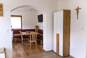 a dining room with a table and a cross on the wall at Appartement Monika in Neukirchen am Großvenediger
