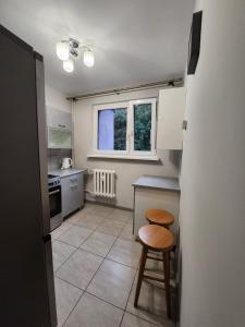 a kitchen with a table and two stools in it at Słoneczny apartament 2 in Duszniki Zdrój