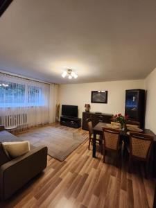 a living room with a table and a dining room at Słoneczny apartament 2 in Duszniki Zdrój