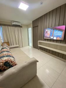 a living room with a couch and a flat screen tv at Caldas Novas - Piazza diRoma incluso acesso ao Acqua Park, Slplash e Slide in Caldas Novas